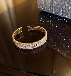 Détail d'un bracelet manchette doré 18K avec trois rangées de zircons carrés et ronds