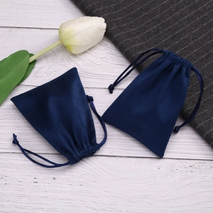 Navy blue flannel drawstring pouch with a white tulip on wood and fabric surface