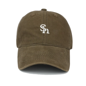 Macro detail of SPn white embroidery on a vintage brown washed cotton baseball cap