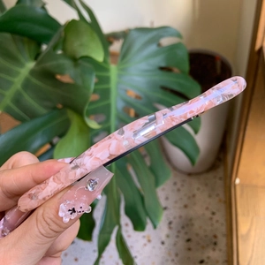 Pink marble acetate hair claw clip with vintage sweet design held in hand