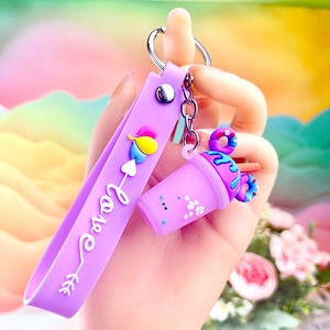 Detail showing a purple milk tea cup keychain with mini donuts and love wrist strap
