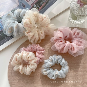 Set di sei elastici per capelli floreali in rete blu, rosa e beige su vassoio