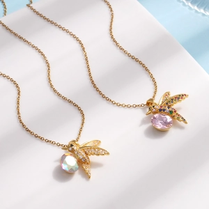 Gold plated hummingbird necklaces with colorful zircon stones on white display