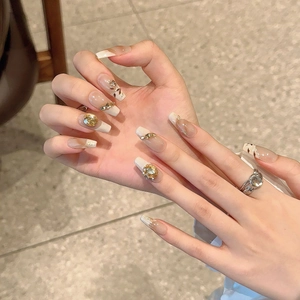 Handmade press-on nails with french nude design, gold foil accents and yellow gemstones