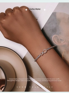 Close-up of a 925 sterling silver infinity symbol charm on a classic snake chain bracelet