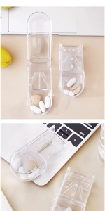 Macro detail of portable clear pill cutter with stainless steel blade and storage compartment