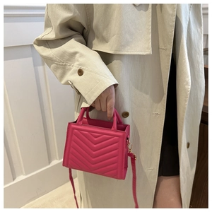 Close-up of fuchsia chevron quilted PU leather handbag with elegant top handles