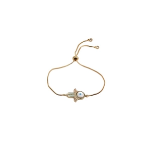 Detail of adjustable gold Hamsa and Evil Eye bracelet with blue zircon crystals