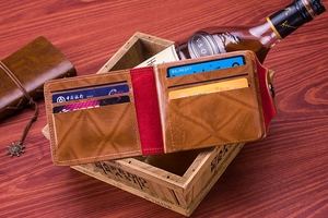 Detailed view of brown leather bifold wallet with multiple card slots and red lining