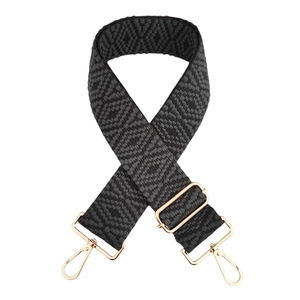 Détail de la bandoulière tissée noire à motifs losanges avec mousquetons dorés brillants