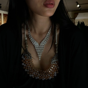 Luxurious silver-tone V-shaped rhinestone fringe necklace set styled with layered beads