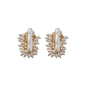 Boucles d'oreilles vintage en or avec perles et tiges en argent sur fond blanc
