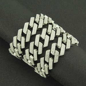 Detailed close-up of a wide silver Cuban link cuff bracelet paved with sparkling rhinestones