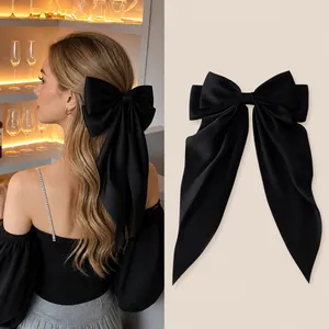 Elegant oversized black satin bow hair clip with long ribbons for women's hairstyles