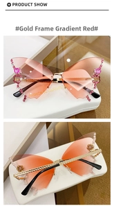 Macro detail of butterfly rimless sunglasses with gradient red lenses and rhinestone accents