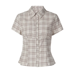 Detail of the brown and white plaid pattern and button closure on the women shirt