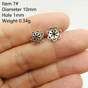 Detailed macro of a 10mm silver flower spacer bead with 1mm hole for DIY jewelry making
