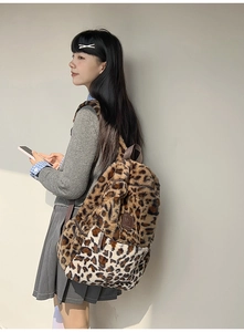 Dettaglio dello zaino di peluche leopardato su modella che mostra consistenza e patch logo