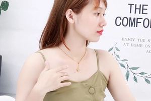 Lifestyle shot showing a model wearing the gold titanium heart pendant necklace