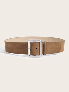 Détail d'une ceinture large en daim marron avec une boucle ardillon carrée argentée