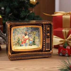 Close-up of retro TV Christmas music box with glowing snow scene and snowman detail