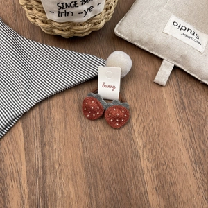 Detail of cute plush strawberry hair ties for girls with red and brown fabric finish