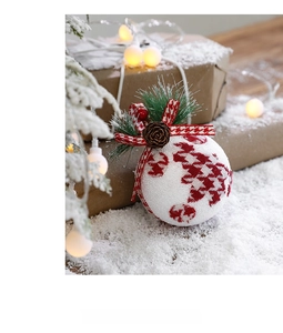 Detail of red houndstooth Christmas ball with pine cones and needles on festive tree