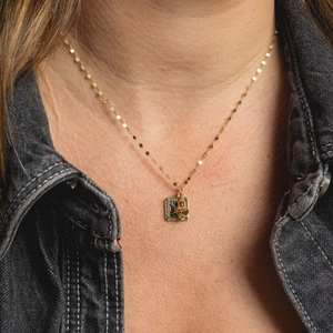 Golden tarot style square pendant necklace featuring LOVE flower design on model