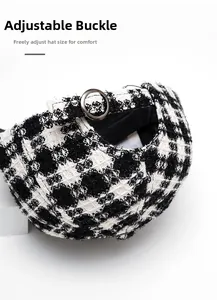 Detail of adjustable metal buckle on a black and white houndstooth plaid baseball cap