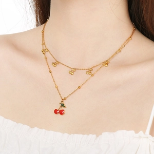 Collier double couche doré avec pendentif cerise rouge porté par un mannequin femme