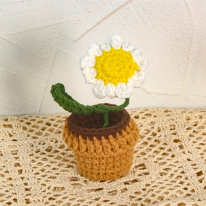 Handmade crochet potted white daisy flower with green leaves in a brown pot