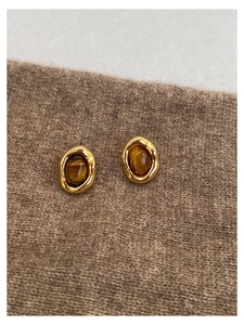Macro di orecchini vintage dorati con trama lavica e pietra occhio di tigre marrone
