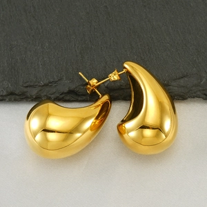 Detail of high-polished 18K gold water-drop stud earrings with sleek metallic luster