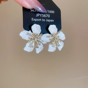 Macro detail of floral earrings with S925 silver needles and rhinestone studded centers