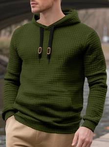 Detail of dark green hoodie featuring waffle texture fabric and black leather drawstring tabs