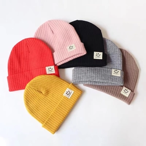 Knitted baby beanies with smiley face patch in red, pink, black, grey, brown and yellow