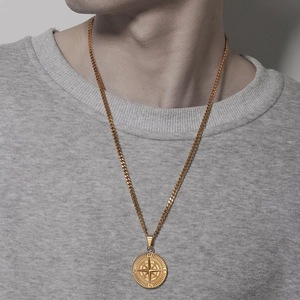 Men's gold compass pendant necklace with cuban chain shown on model in urban punk style