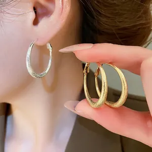Créoles chic en or et argent mats avec une élégante texture métallique brossée