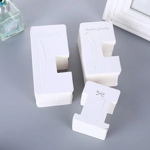 White paper jewelry display cards with hanging holes for hair clips and necklaces