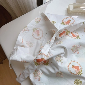 Close-up of floral print tote bag handle and lightweight fabric texture on white surface