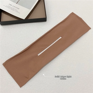 Macro detail of a light coffee fabric deft bun hair maker tool with reinforced stitching