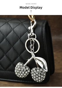 Macro shot of sparkling rhinestone double cherry charm on black quilted leather bag