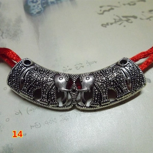 Retro elephant metal pendant with red woven cord on vintage calligraphy background