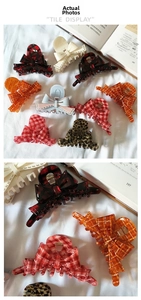 Detail of colorful acetate bow hair claw clips showing polished texture and metal spring