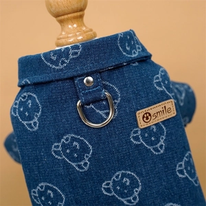 Detail of blue denim pet vest with smile leather patch and metal D-ring attachment