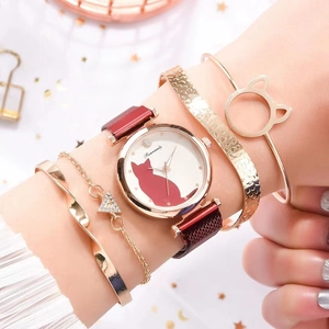 Close-up of elegant rose gold cat watch and gold bracelet set on woman's wrist