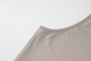 Detailed view of high-stretch knit fabric and premium stitching on taupe sleeveless top