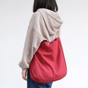 Japanese style red canvas tote bag shown on a model in a minimalist casual setting