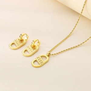Detail showing gold teardrop pendant and twist chain jewelry set with metallic luster