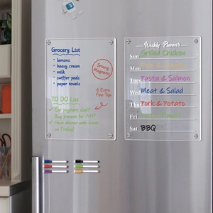 Macro view of magnetic acrylic weekly planner and grocery list set on a stainless fridge